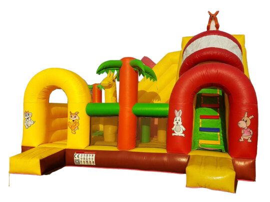 An inflatable combo unit with a bounce house, slide, and climbing wall, surrounded by green grass and trees.